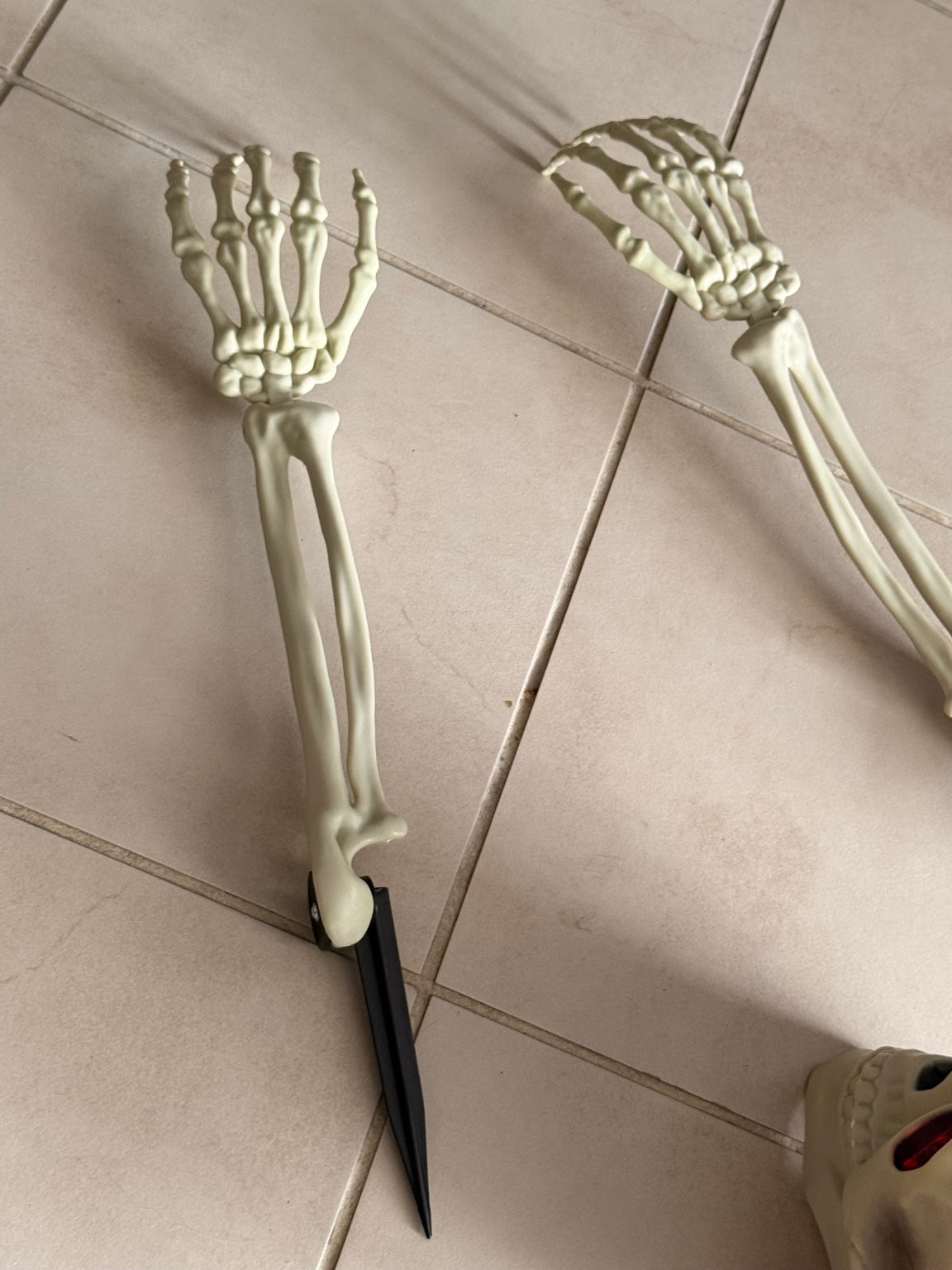 Close-up of the two skeleton arm stakes in the Halloween garden set