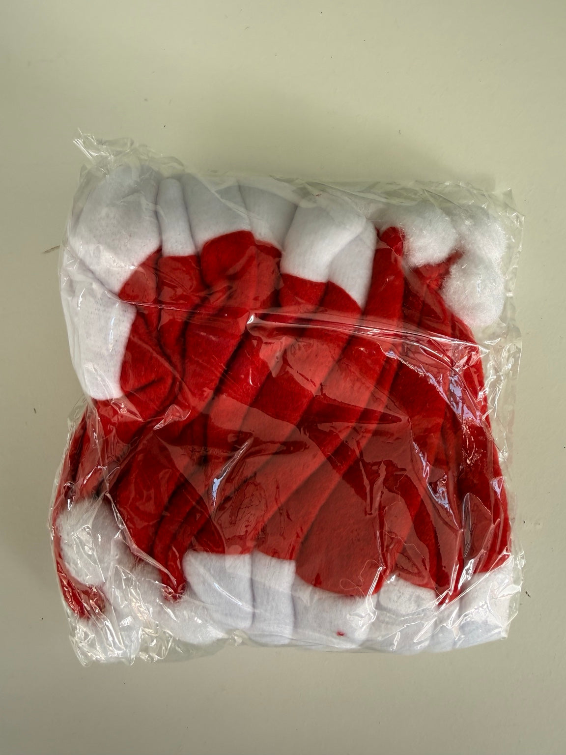 Set of 10 mini red and white Santa hats laid out